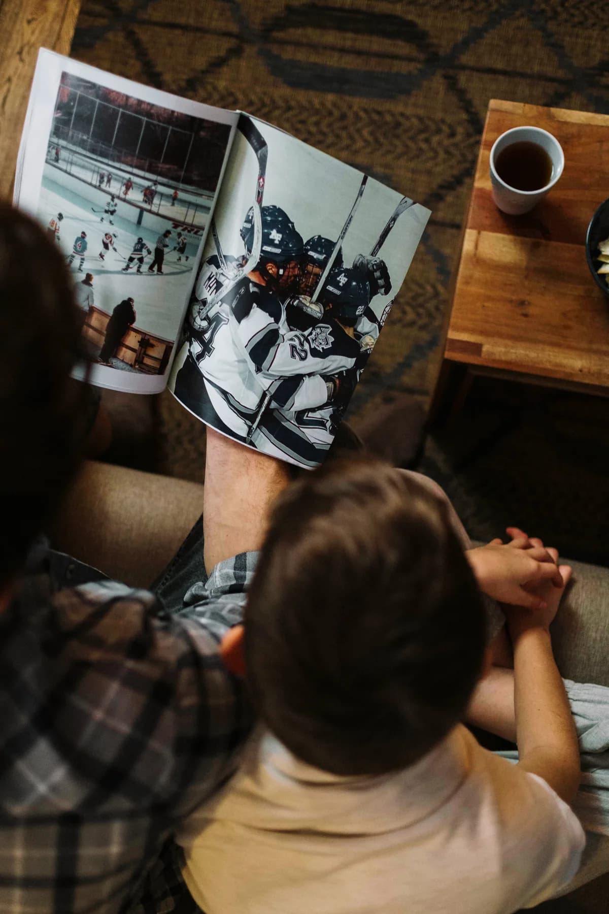 Far og sønn som ser i en fotobok sammen